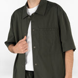 model is wearing seersucker drawstring shorts and seersucker short sleeved shirt in deep green colour