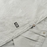 drawstring and NFC tag details of the seersucker short sleeved shirt in grey colour