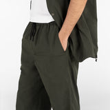 model is wearing seersucker drawstring pants and seersucker shirt in deep green colour