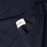 Dettaglio etichetta MONOBI del maglione COTTON CASHMERE WHOLEGARMENT 18G / NAVY MELANGE