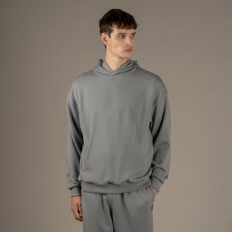 La modella indossa una felpa loungewear in lana superiore con cappuccio di colore grigio