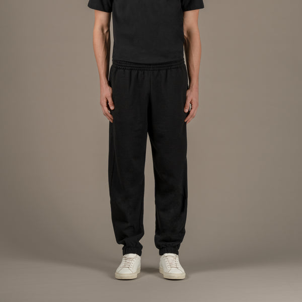 La modella indossa joggers loungewear in lana di qualità superiore di colore nero, sul davanti