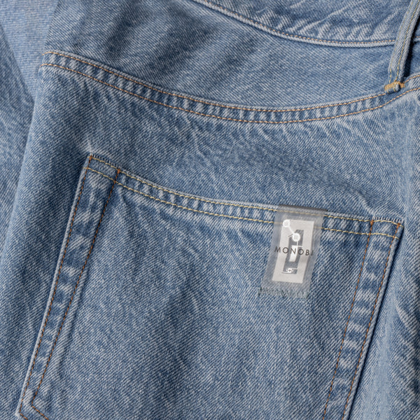 detail of the back pocket and nfc tag of the MONOBI denim pants