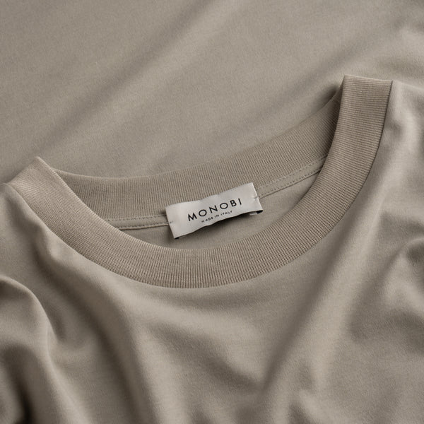 detail of the ribbed collar and MONOBI label on the ice-coloured T-shirt