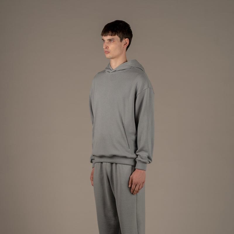 Model wears superior wool loungewear hoodie color grey, 3/4.