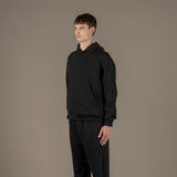 Model wears superior wool loungewear hoodie color black, 3/4.