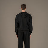 Model wears superior wool loungewear hoodie color black, back.