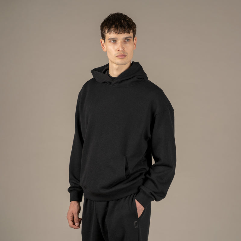 Model wears superior wool loungewear hoodie color black