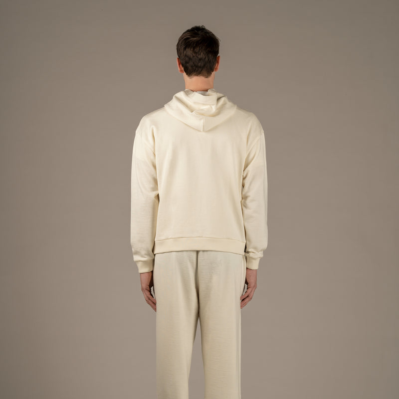 Model wears Superior Wool Loungewear Hoodie color naturale, back