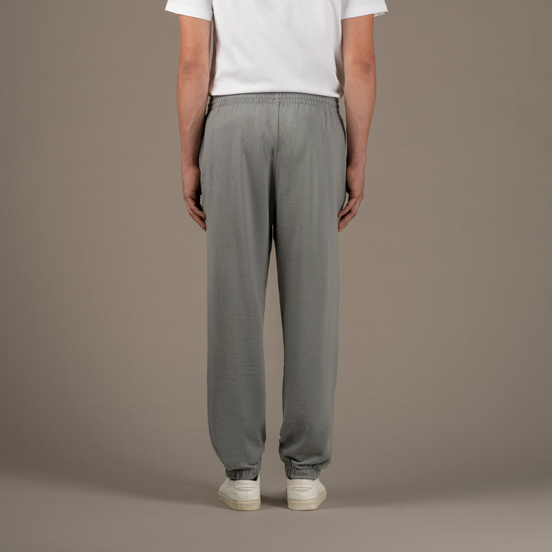 Model wears superior wool loungewear joggers color grey, back