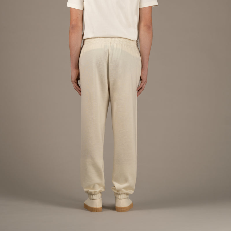 Model wears superior wool loungewear joggers color naturale, back