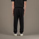 Model wears superior wool loungewear joggers color black, back